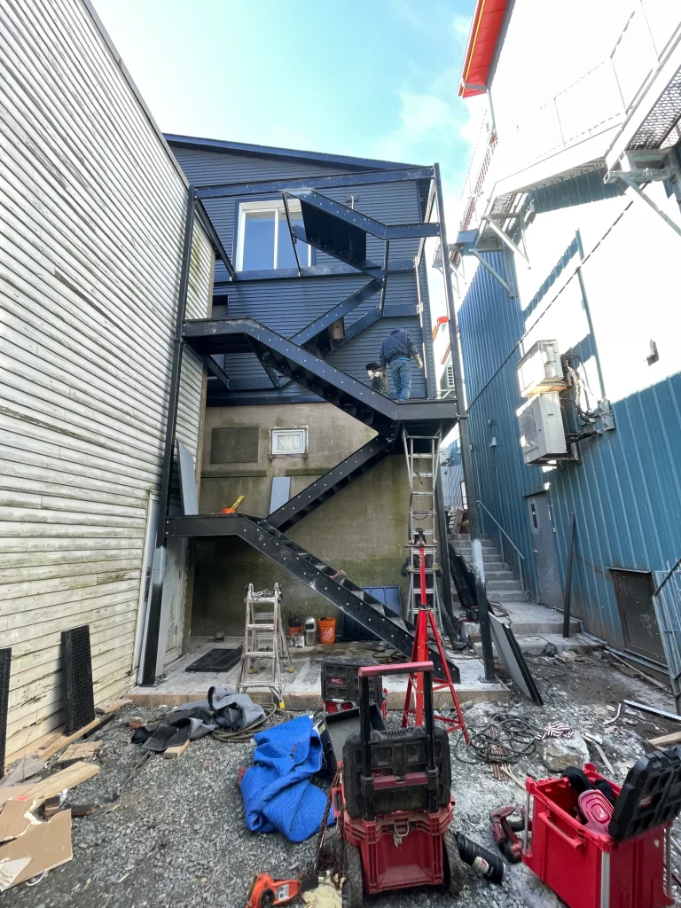 Exterior stair installation in a constrained service area by BriteArc Fabricators