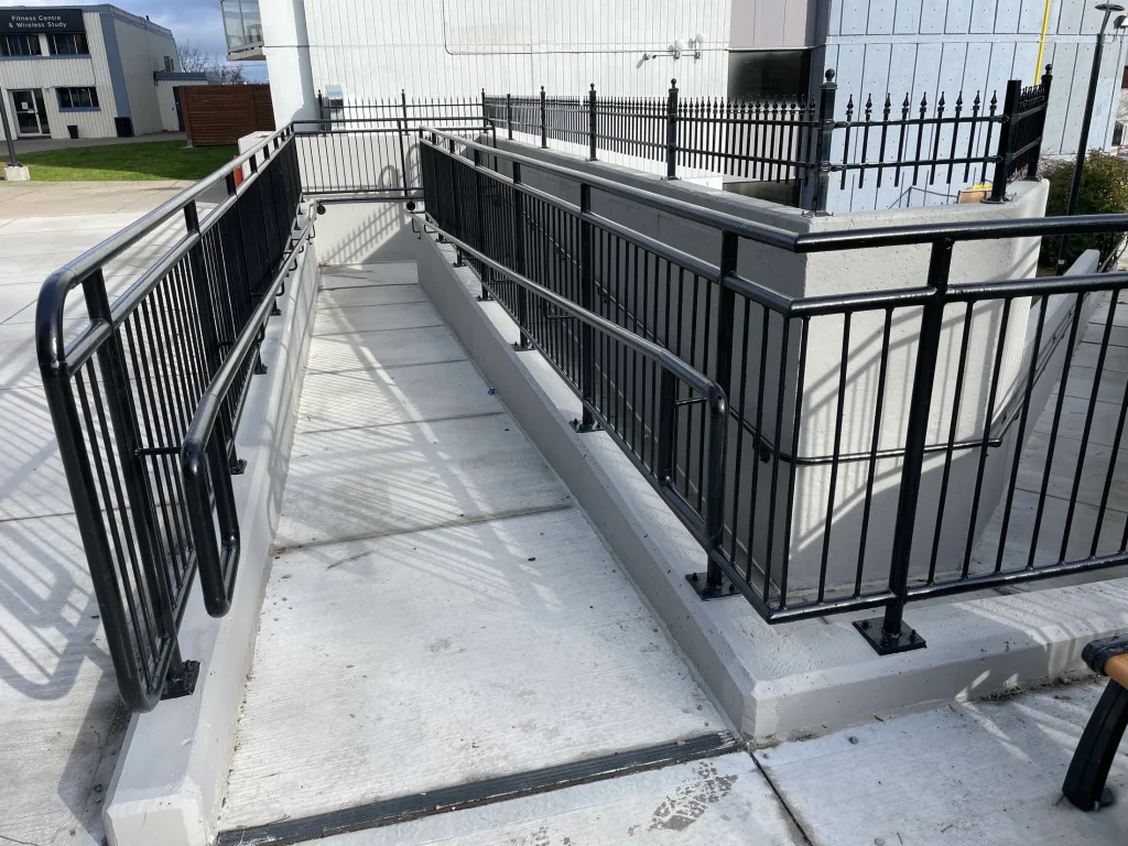 Guardrails enclosing an exterior landing and ramp by BriteArc Fabricators