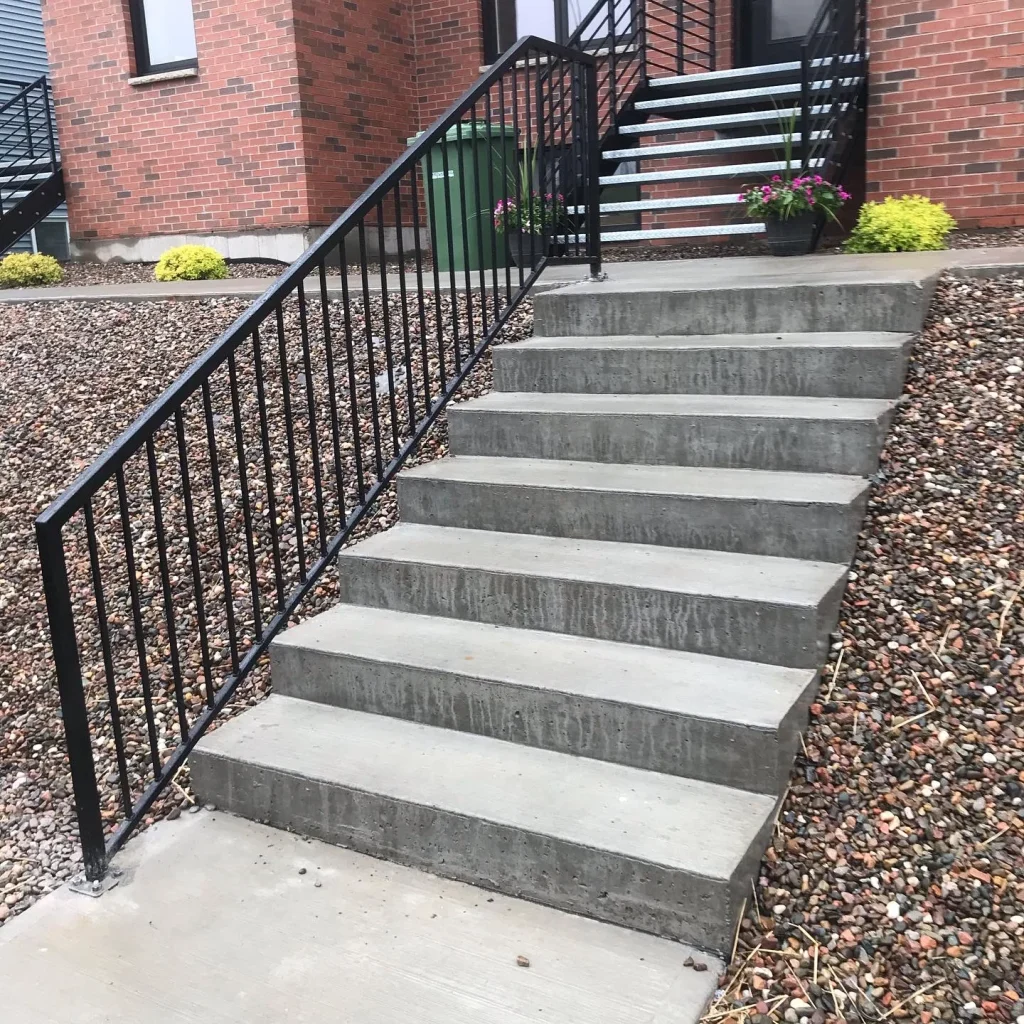 Completed exterior stair railings on concrete steps by BriteArc Fabricators