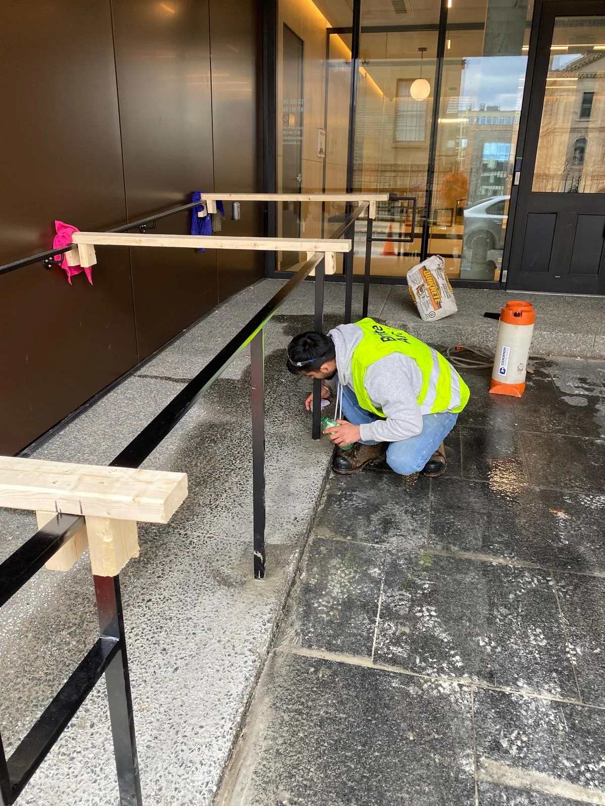 Drilling and fitting handrail supports on site by BriteArc Fabricators