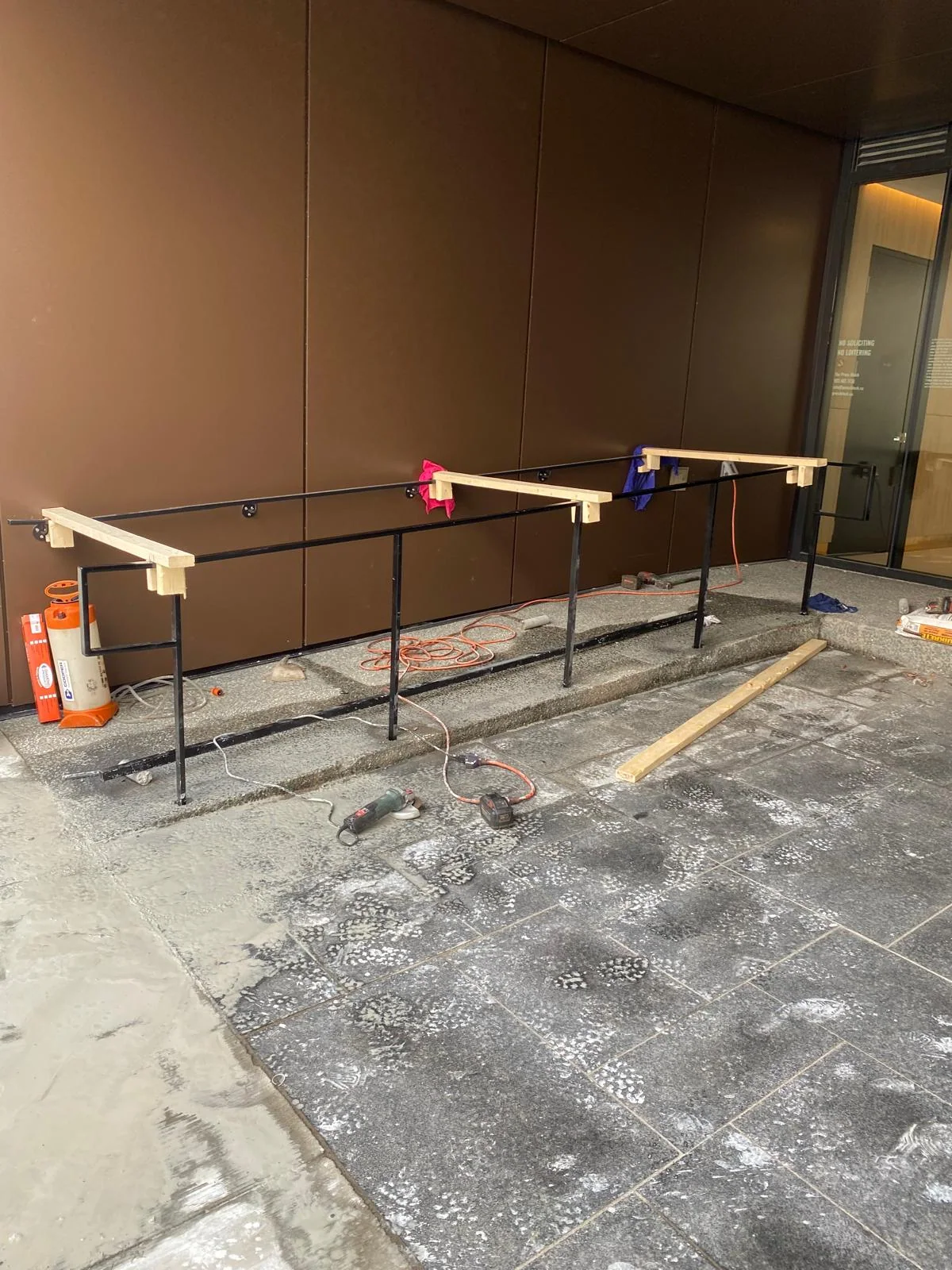 Freestanding handrail aligned along an exterior route by BriteArc Fabricators