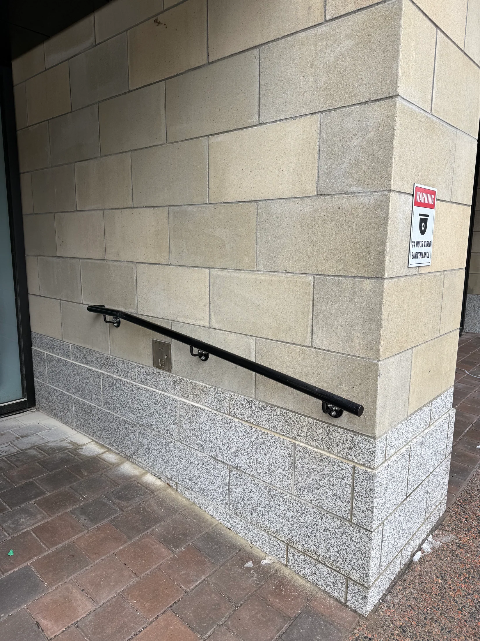 Wall-mounted handrail beside a commercial doorway by BriteArc Fabricators