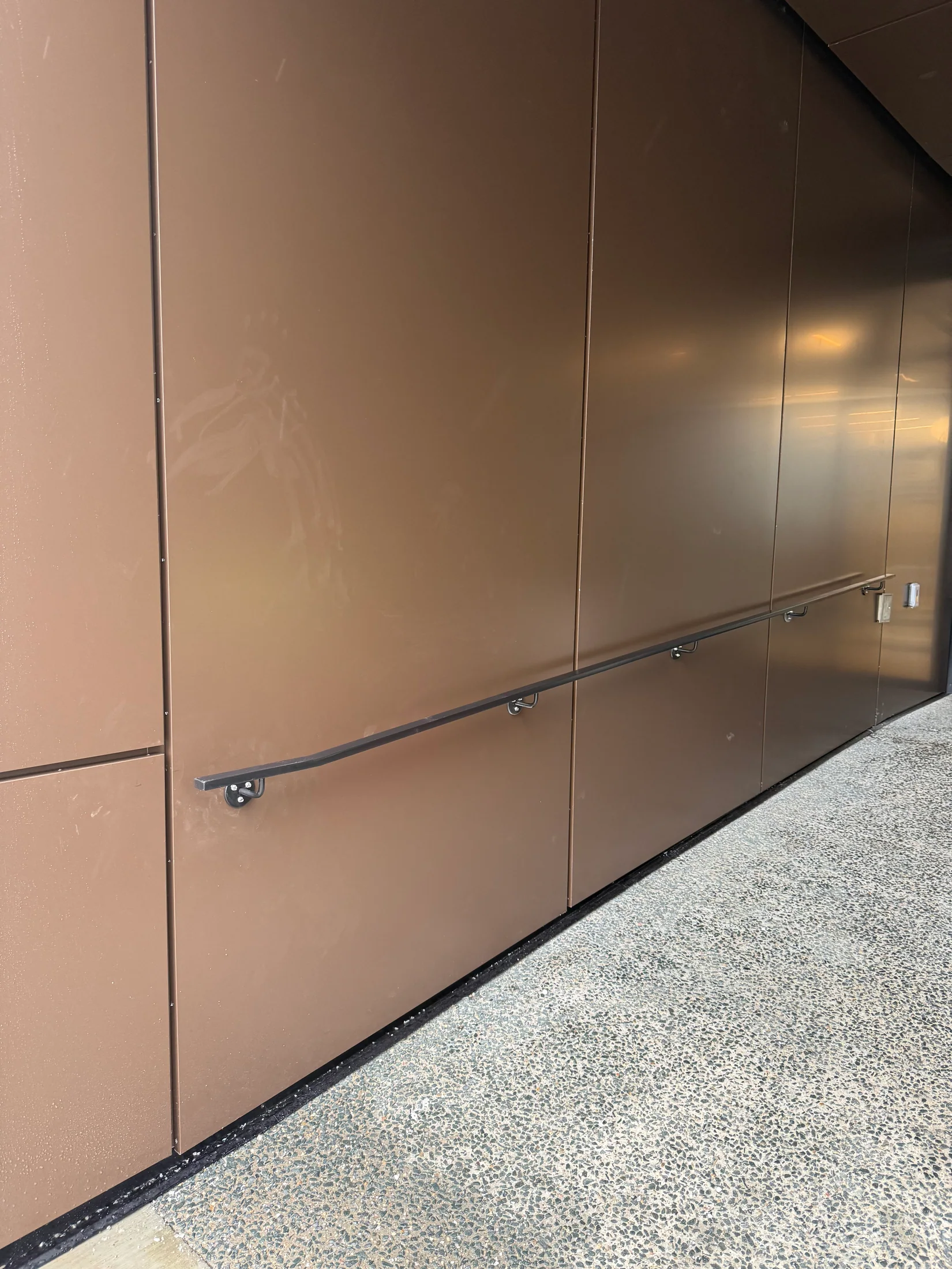 Finished handrail along a metal-clad wall by BriteArc Fabricators