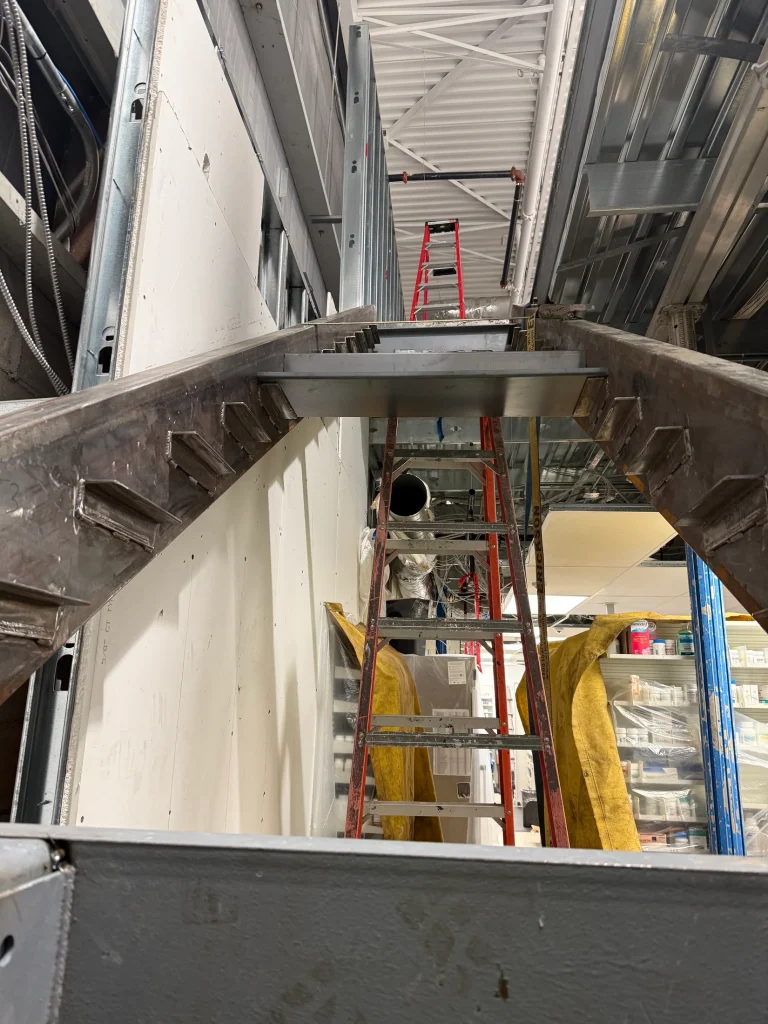 Landing and support steel fitted beside an existing wall by BriteArc Fabricators