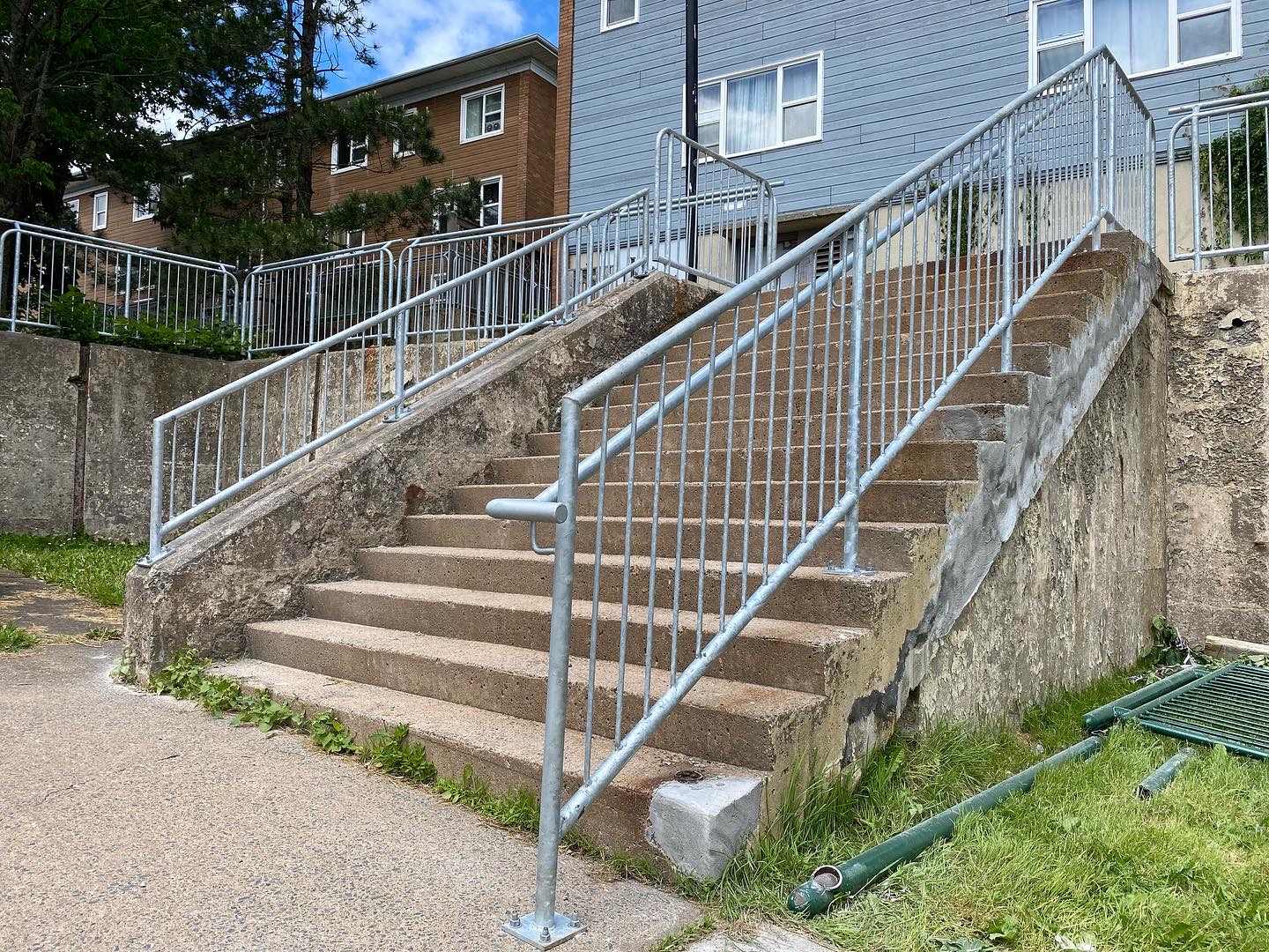 Completed two-sided galvanized railing system on public concrete stairs