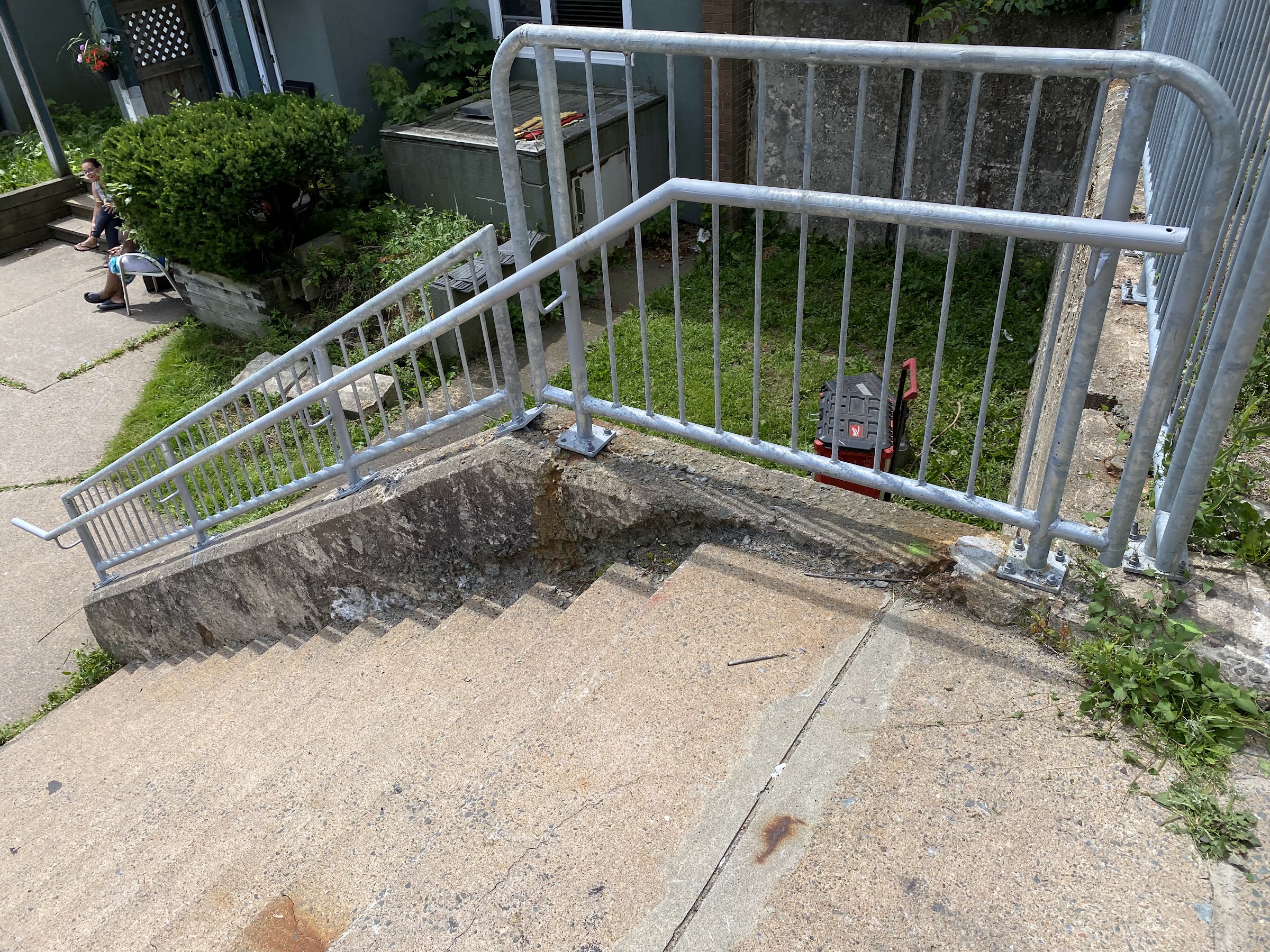 Close view of galvanized railing posts and handrail transitions at a stair landing