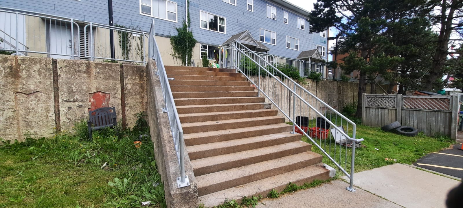 Wide view of completed galvanized railings across a public staircase