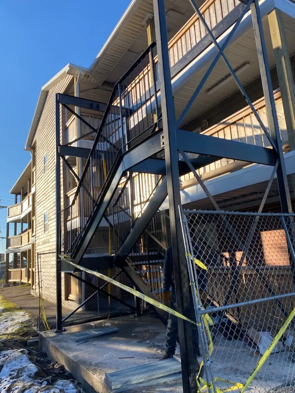 Multi-level steel fire escape at an apartment building by BriteArc Fabricators