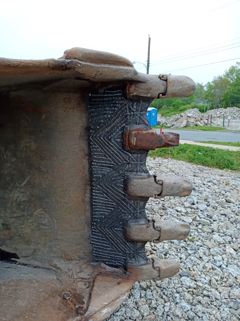 Hardfacing applied around bucket tooth shanks by BriteArc Fabricators