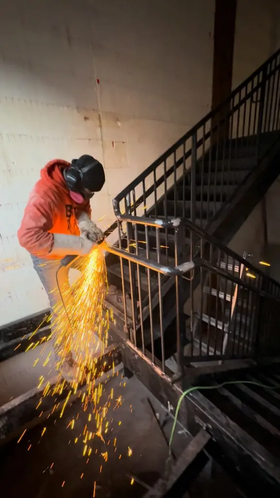 Field welding on an installed stair and guardrail by BriteArc Fabricators