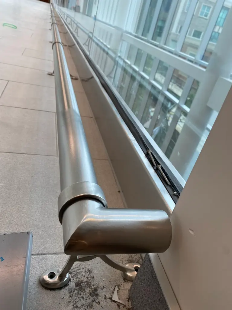Stainless handrail return and bracket detail by BriteArc Fabricators