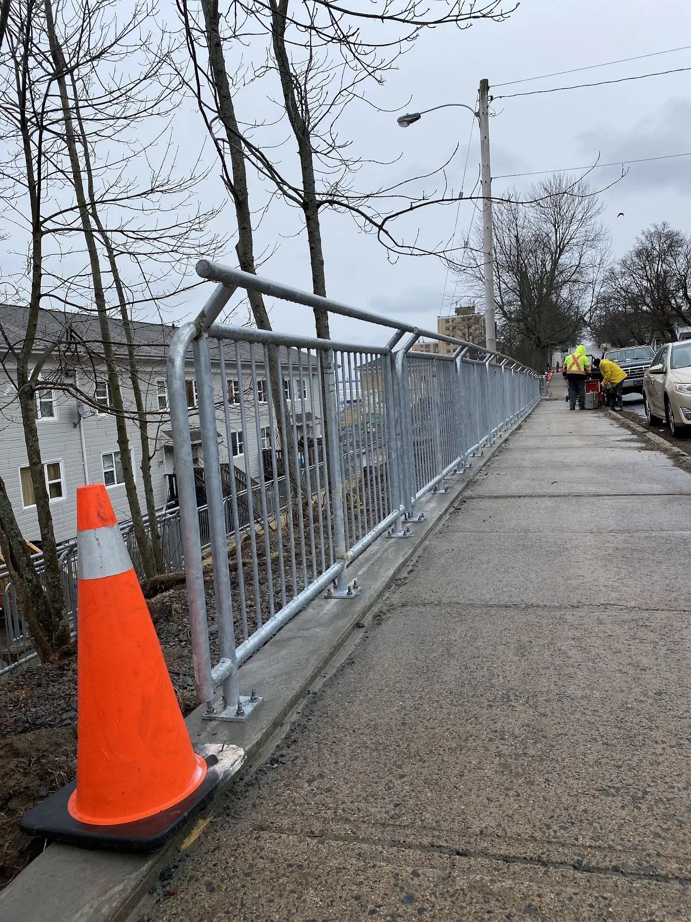 Long galvanized steel guardrail installed beside a public walkway